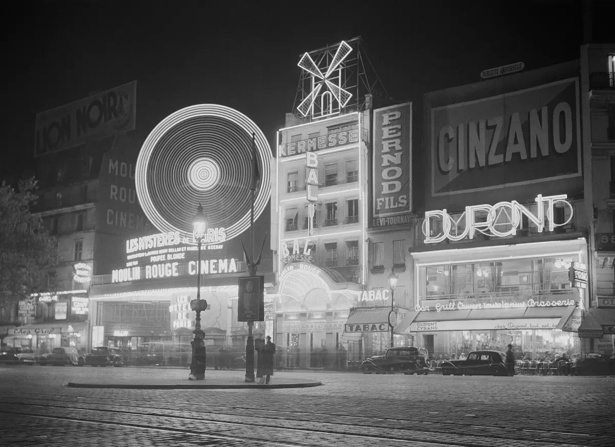 The Moulin Rouge at night in a historic photo