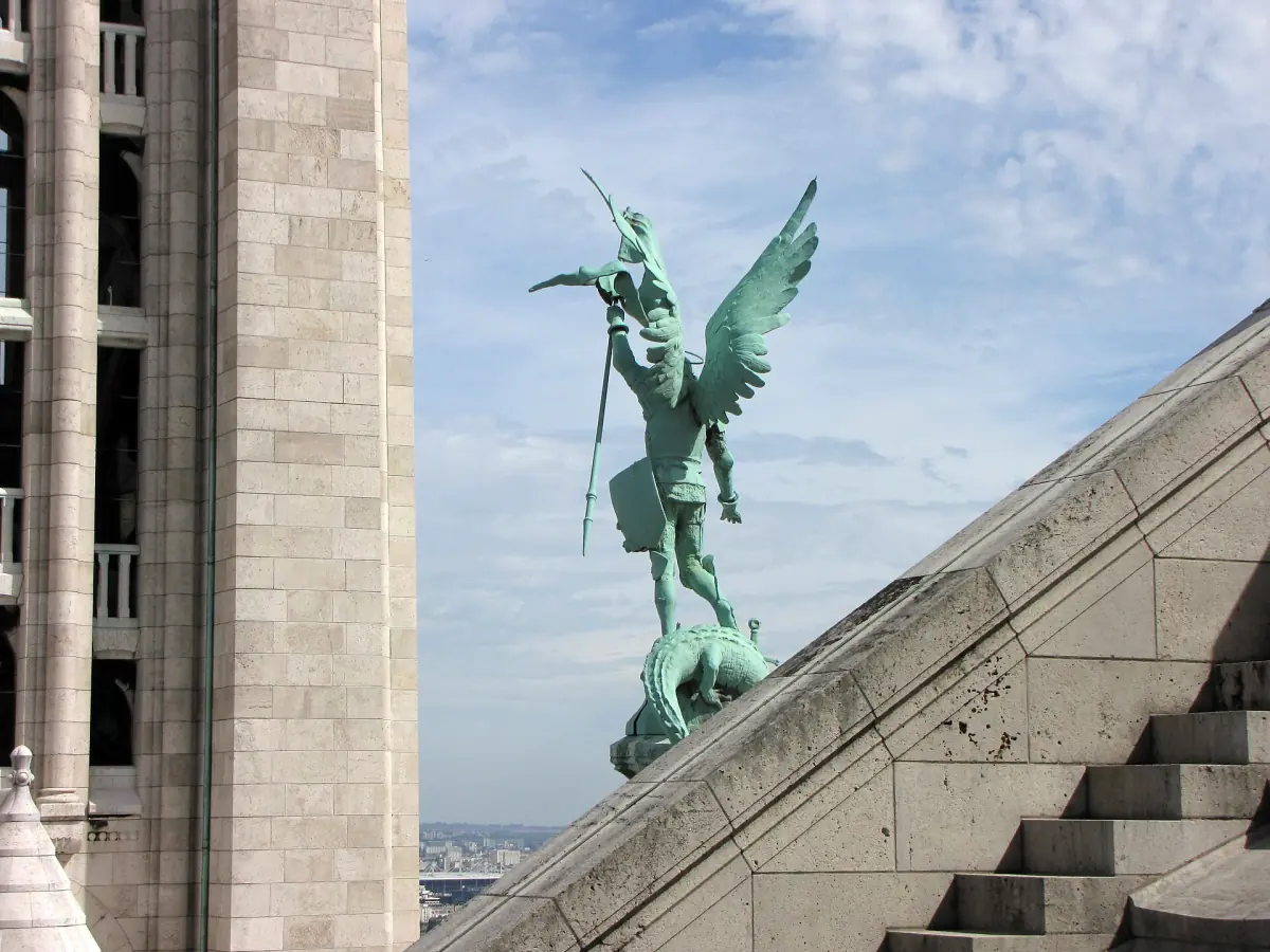 A bronze statue on the roofline of the basilica